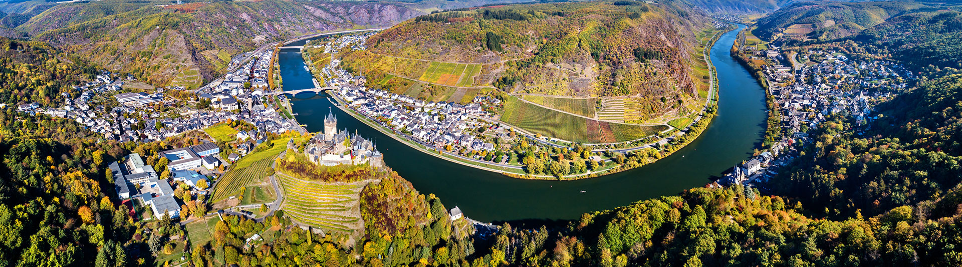 Aerial view of a vineyard-lined river loop and its villages